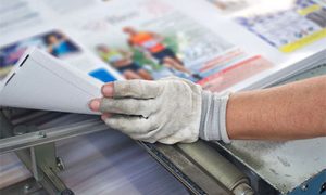 Hand with Glove Holding Papers After Printing in Boston, Newton, Plymouth, Revere, Somerville, and Worcester