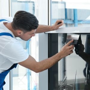 Contractor Performing a Storefront Window Tinting Installation in Cambridge, MA